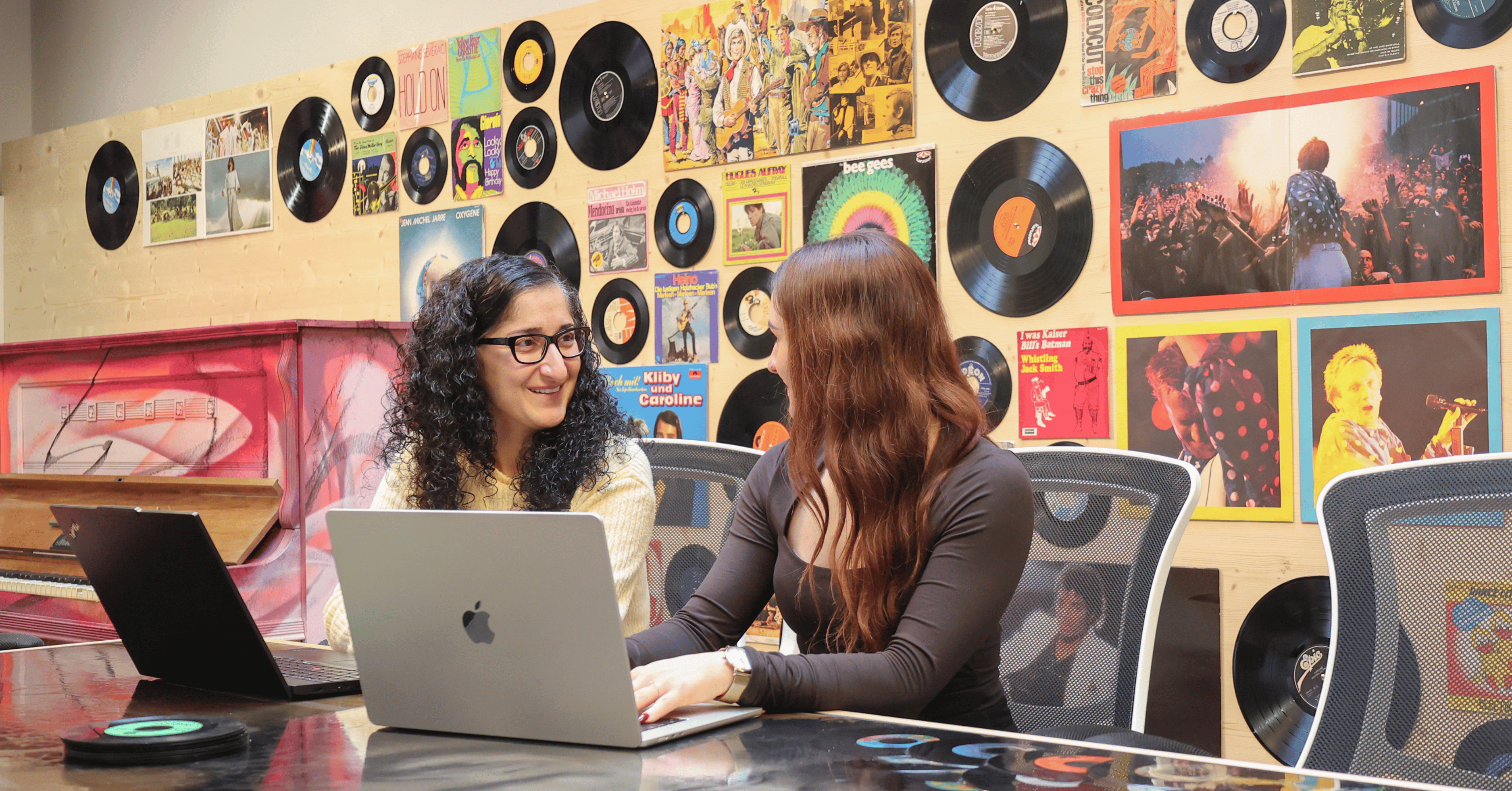 2 Personen arbeiten in unserem Besprechungsraum Musikzimmer.