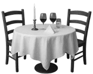 Zwei Stühle an einem Tisch und darauf stehen zwei Weingläser und ein Kerzenständer