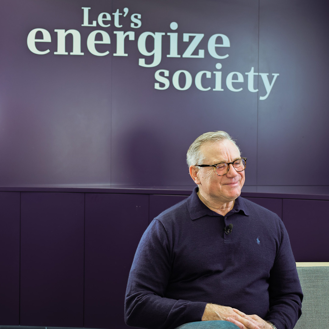 Ralf Goerdemann vor einer Wand mit der Aufschrift Let's energize society