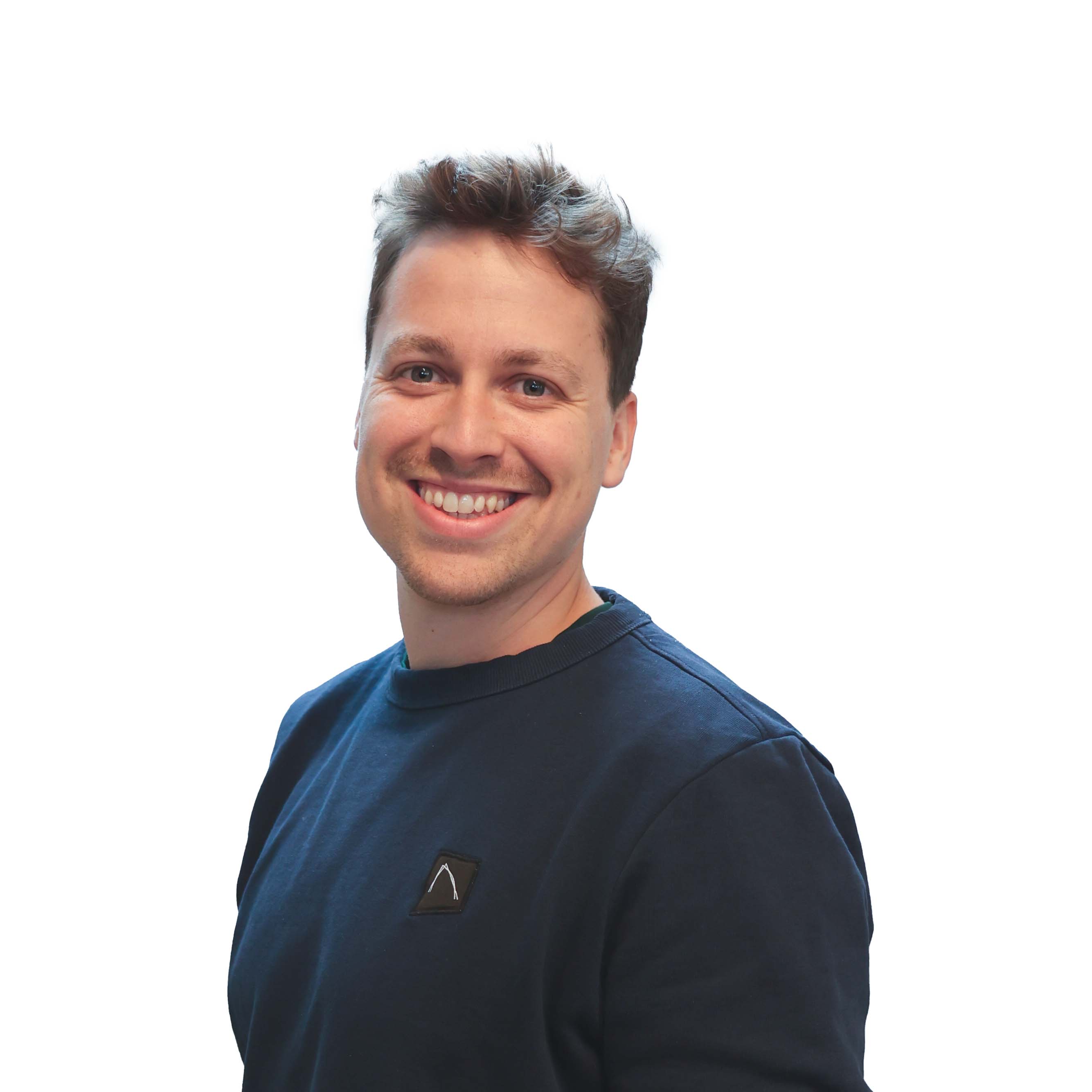 Ein lächelnder, junger Mann mit dunkelblonden, kurzen Haaren und einem dunkelblauen Pullover.