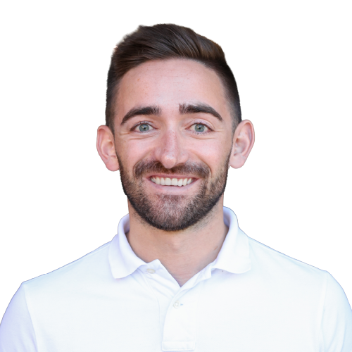 Ein lächelnder, junger Mann mit kurzen, braunen Haare, einem dunkelbraunen Bart und einem weißen Oberteil.