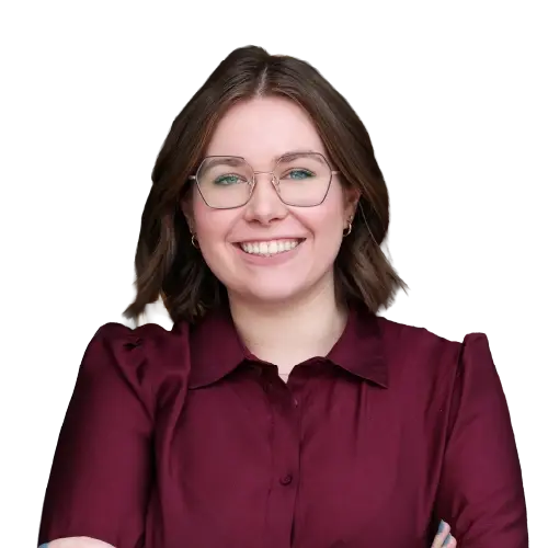 Ein lächelnder, junger Mann mit einer Halbglatze, einem dunkelblonden Bart und einem lilafarbenen Oberteil.